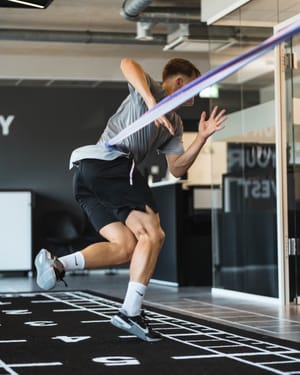 Sportler springt im KINGS360-Center über eine Bodenmarkierung