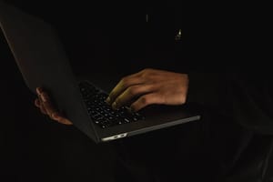 Hände tippen auf einem Laptop im Dunkeln